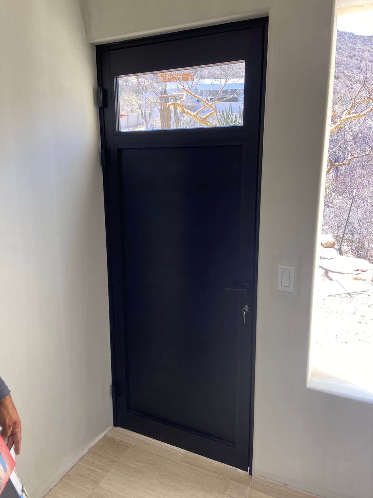 Puerta negra con vidriera